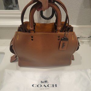 Coach Rogue in saddle with dust bag